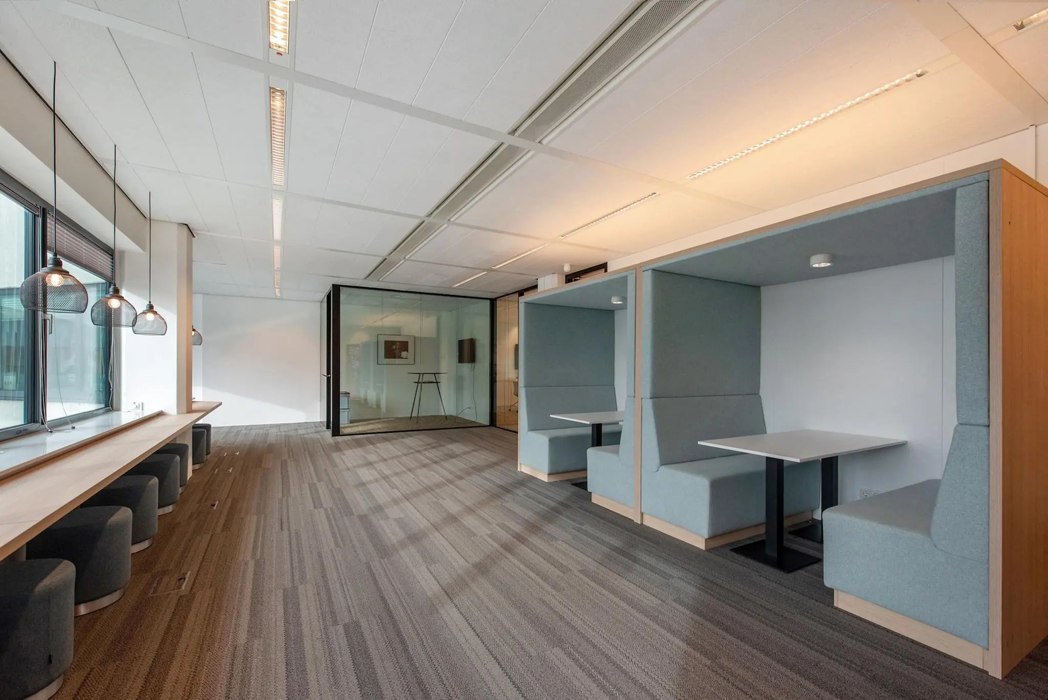 Moderne kantoorruimte aan de Grote Marktstraat met werkplekken in nissen en een lange werktafel bij het raam.